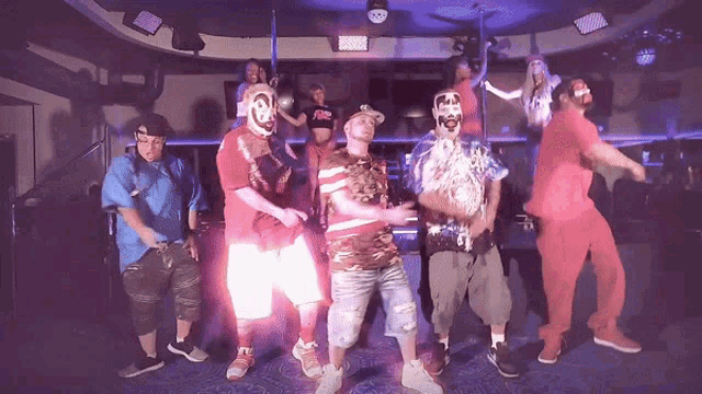 a group of people are dancing in a dark room and one of them is wearing a shirt that says a&f