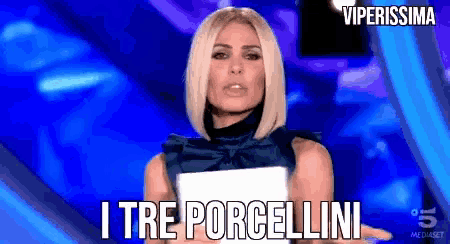a woman holding a piece of paper that says i tre porcellini on it