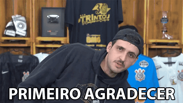 a man wearing a black sweatshirt with the words primeiro agradecer