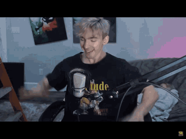 a man wearing a black shirt that says " rude " on it