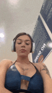 a woman wearing headphones is standing in front of a sign that says no smoking