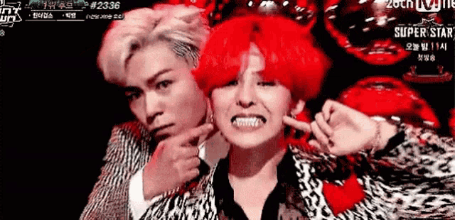two men with red hair are making funny faces on a stage .
