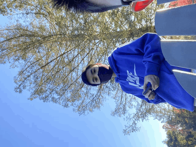 a man wearing a blue nike hoodie looks down at something