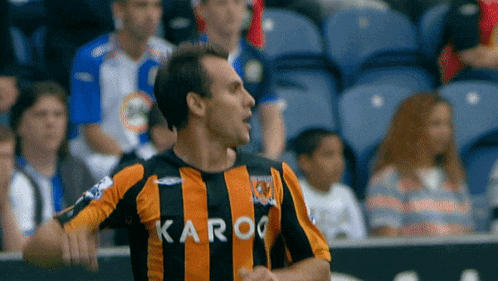 a man wearing a black and orange striped shirt with karoo on it