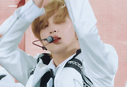 a close up of a person wearing a microphone and a white jacket