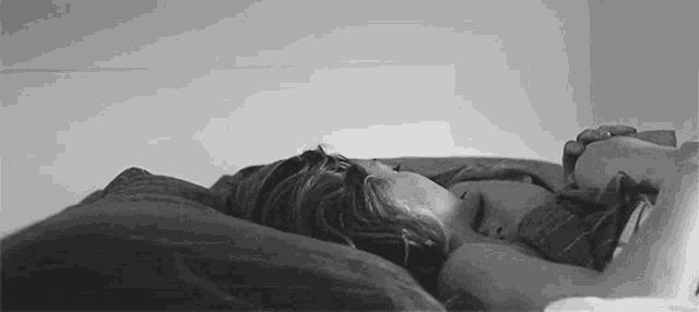 a man and a woman are sleeping on a bed together .