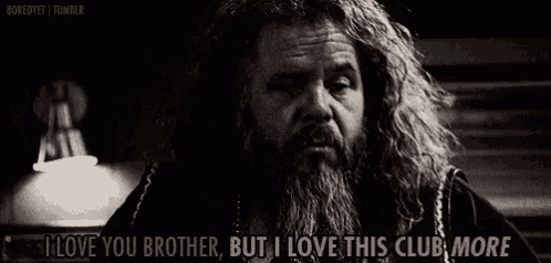 a man with long hair and a beard is talking to another man .
