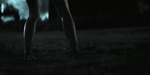 a person 's feet are visible in the dark in a blurry photo