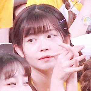 a close up of a girl 's face with a watch on her wrist