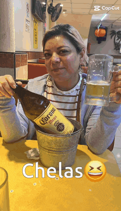 a woman is pouring a bottle of corona from a bucket