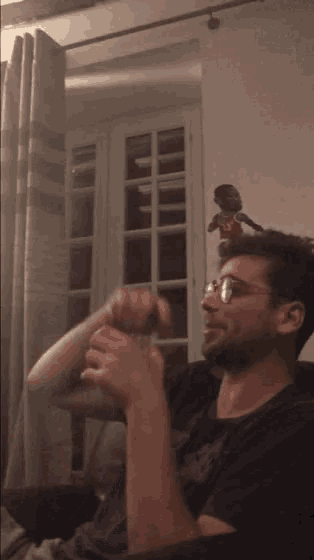 a man wearing glasses is sitting in a chair