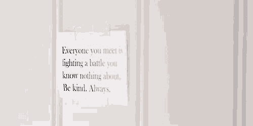 a white piece of paper with a quote on it is hanging on a wall .
