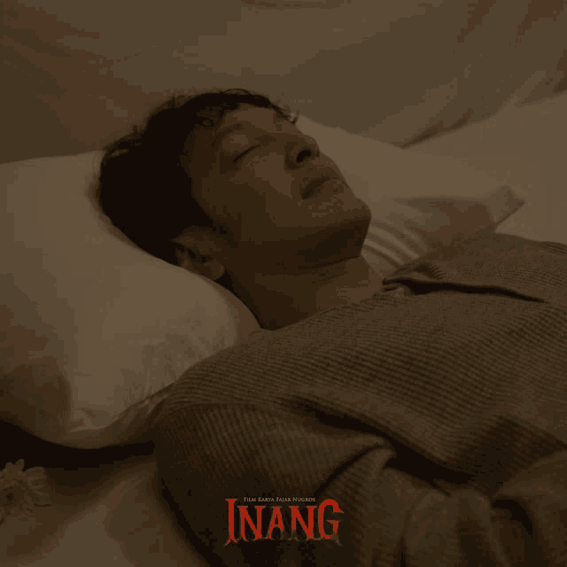 a man is laying on a bed with the word inang on the bottom