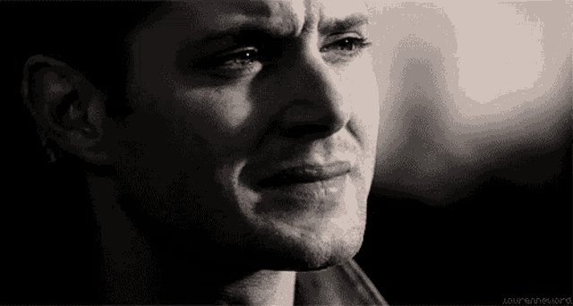 a close up of a man 's face with a tear running down his cheek .