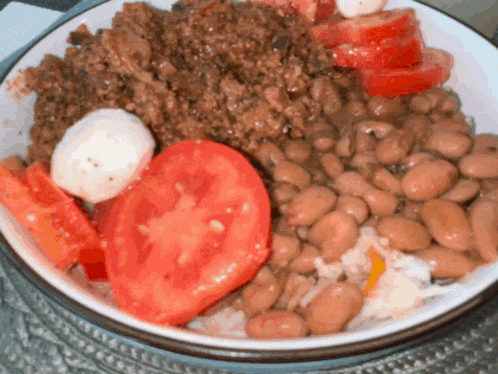 a bowl of food with beans and tomatoes in it