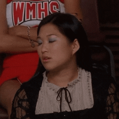 a woman wearing a wmhs cheerleader uniform sits with her eyes closed