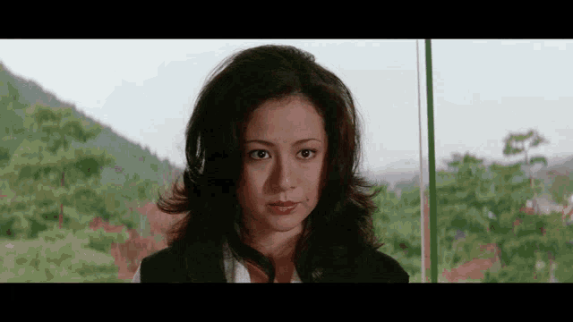 a woman is standing in front of a window looking at the camera .