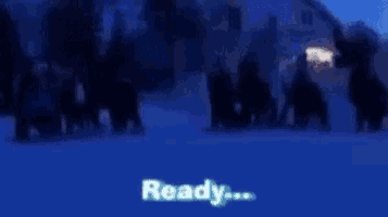 a group of people are standing in the snow and the words get set are on the screen