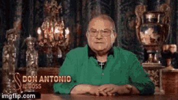 a man in a green shirt is sitting at a table with a sign that says don antonio ill boss