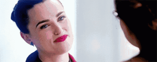 a close up of a woman 's face with red lipstick and glasses .