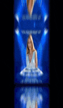 a blurry picture of a woman in a blue dress on a blue background .