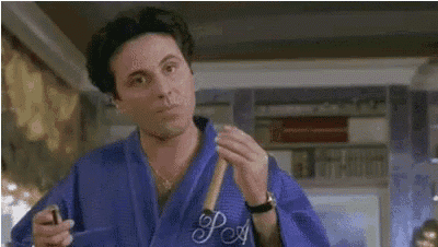 a man in a blue robe is holding a cigarette and saying faut que j ' reflechisse .