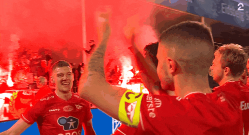 a group of soccer players wearing red jerseys with the word craft on the front