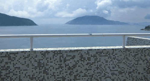 a balcony overlooking a body of water with a mountain in the distance