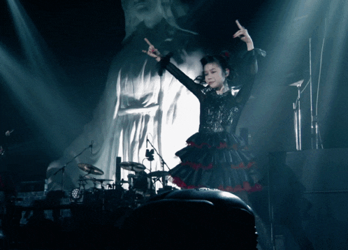 a woman in a black and red dress is giving the middle finger