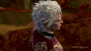 a woman with white hair is wearing a red and gold jacket and a mask .