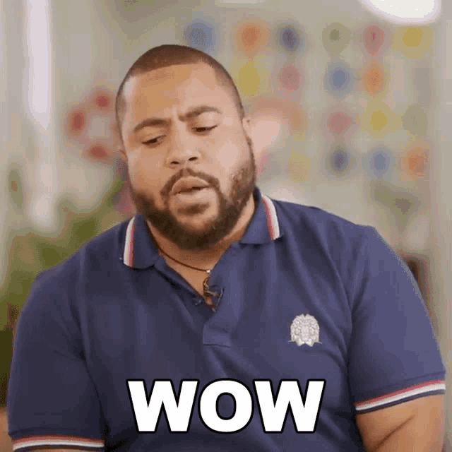 a man with a beard wearing a blue shirt that says wow on it