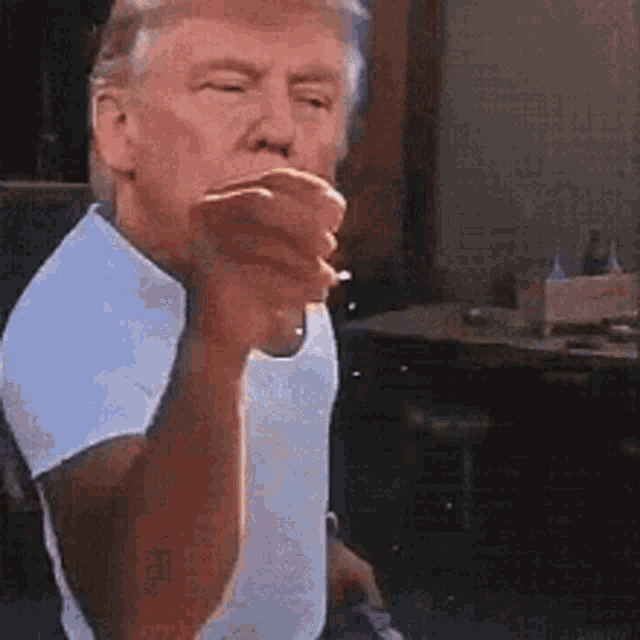 a man in a white shirt is smoking a cigarette and pointing .