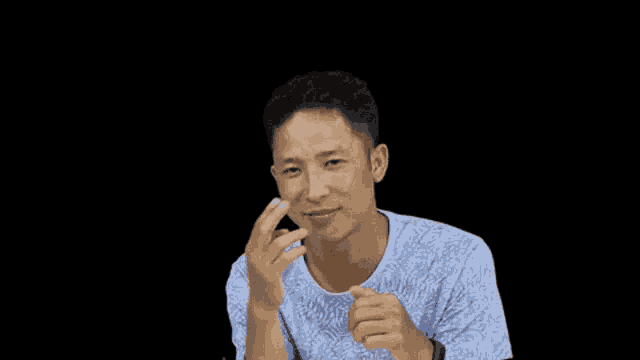 a man wearing a blue shirt is making a funny face