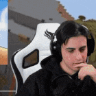 a man is wearing headphones and sitting in a chair .