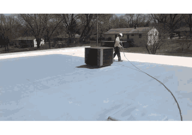 a man is working on a roof with a hose attached to him