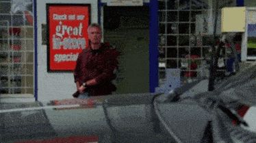 a man stands in front of a store with a sign that says great in store special