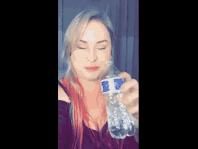 a woman with red hair is smiling and holding a water bottle