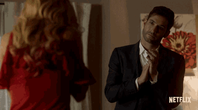 a man in a suit is standing in front of a woman in a red dress and a netflix logo