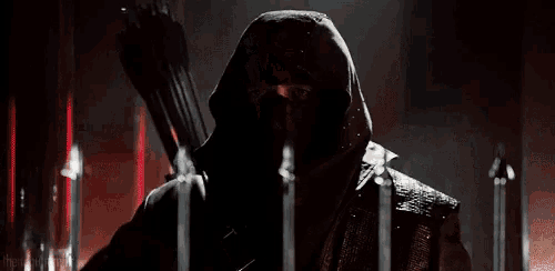 a man in a leather jacket is standing in a dark room with his mouth open and holding a gun .