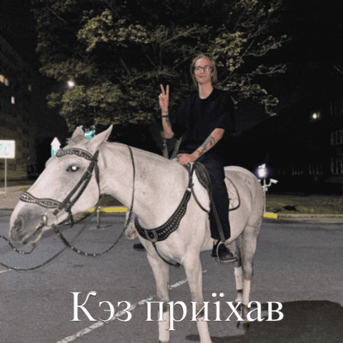a man is riding a white horse with the word kaz on the bottom