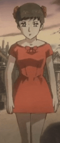 a girl in a red dress is standing in front of a building in a city .