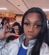 a woman with a nose ring is making a funny face while sitting on a plane .