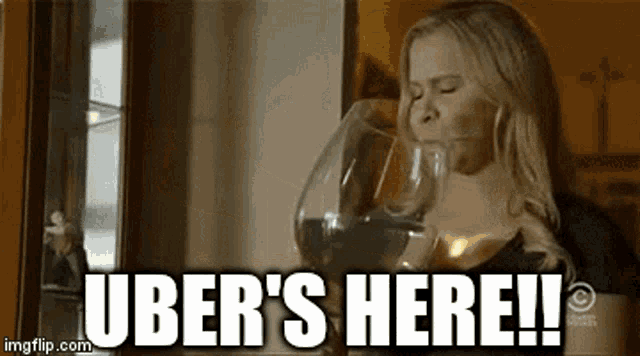 a woman is drinking a glass of wine and the caption uber 's here