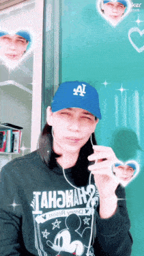 a person wearing a blue la hat and a black shirt