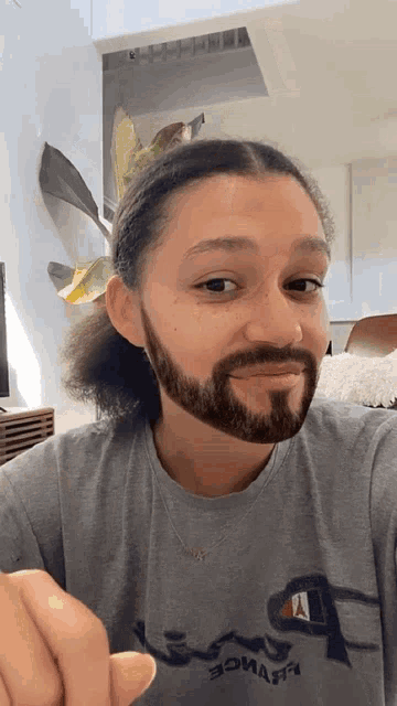 a man with a beard wearing a grey champion shirt