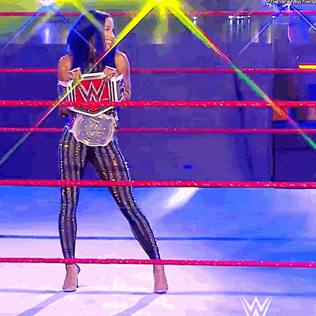a woman in a wrestling ring holds a wwe championship belt