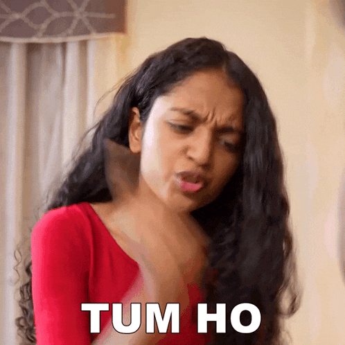 a woman in a red shirt is making a face and says tum ho