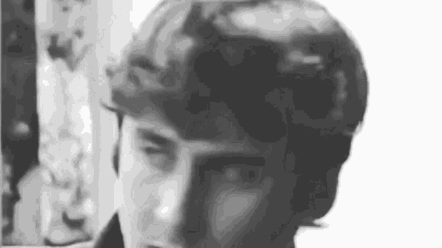 a close up of a person 's face in a black and white photo with a blurred background .
