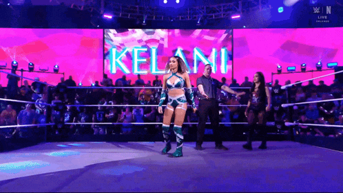 a woman in a wrestling ring with the name kelani on a large screen