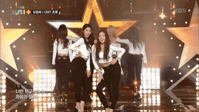a group of girls are dancing on a stage with the kbs logo in the corner